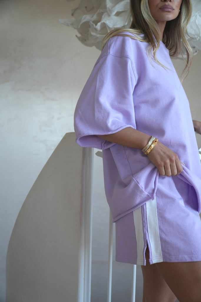 Woman wearing a light purple dress with a white background