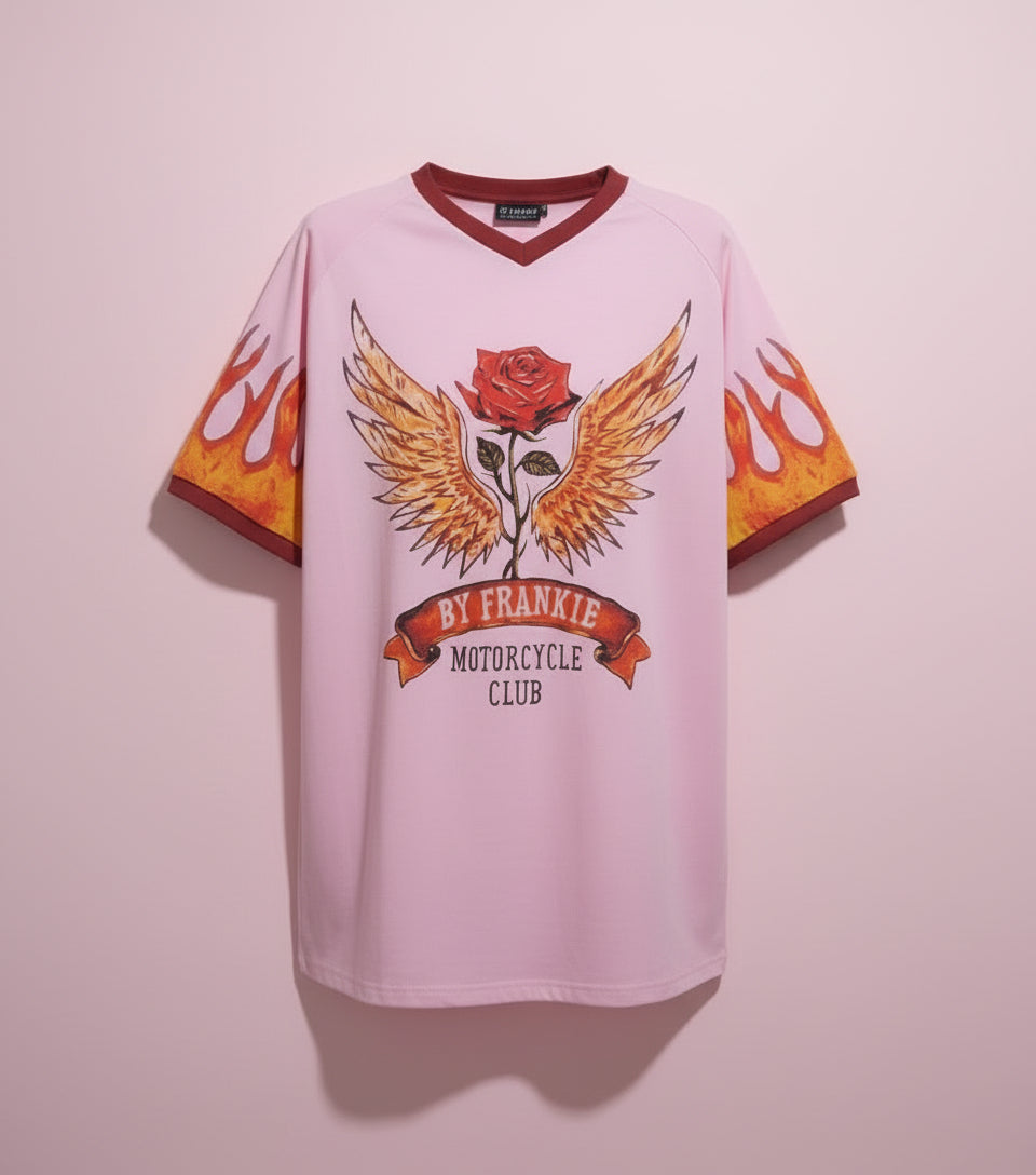 Person wearing a pink oversized t-shirt with a graphic design, standing against a plain background.